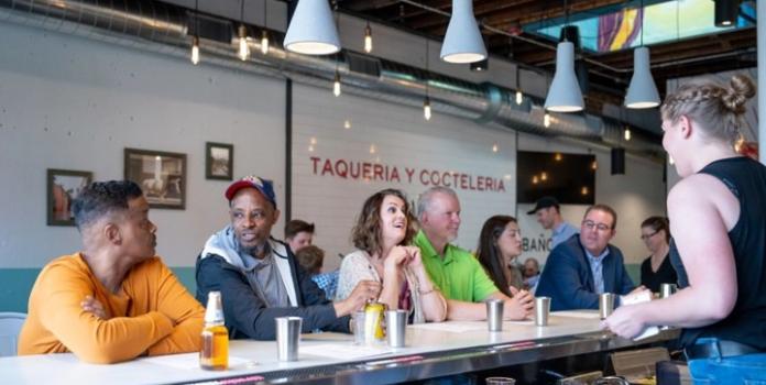 Patrons sitting at the bar at Taco Uprising in Denver, CO.