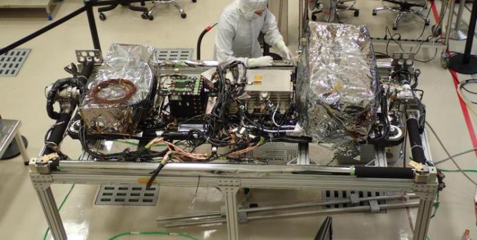 Overhead shot of person working on machinery in lab in protective suit