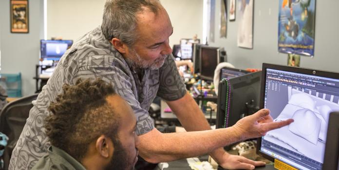 A professor helps student with digital design