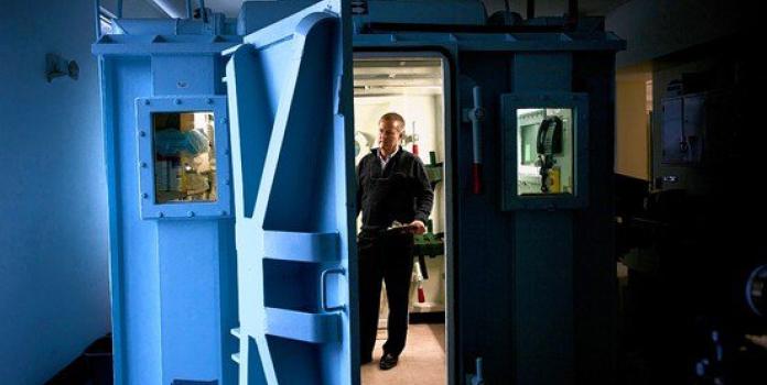 Man stands inside hyperbaric apparatus 