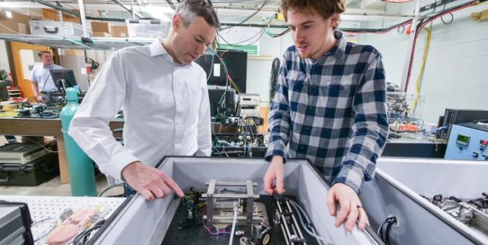 Longpath co-founder Greg Rieker working in CU Boulder lab with colleague