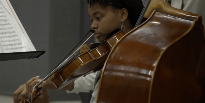 A young woman plays a violin