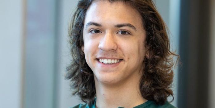 A young man smiles for a portrait