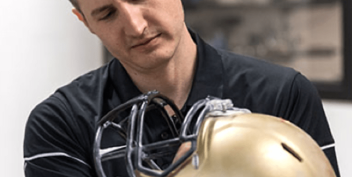 Chris Yakacki inspects the inside of a football helmet