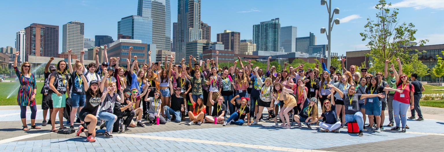 Students attending LYNX National Arts & Media Camps enthusiastically pose for a photo outside