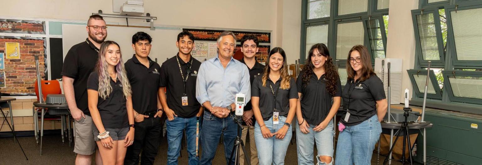 Mark Hernandez and students pose for a group photo in a classroom