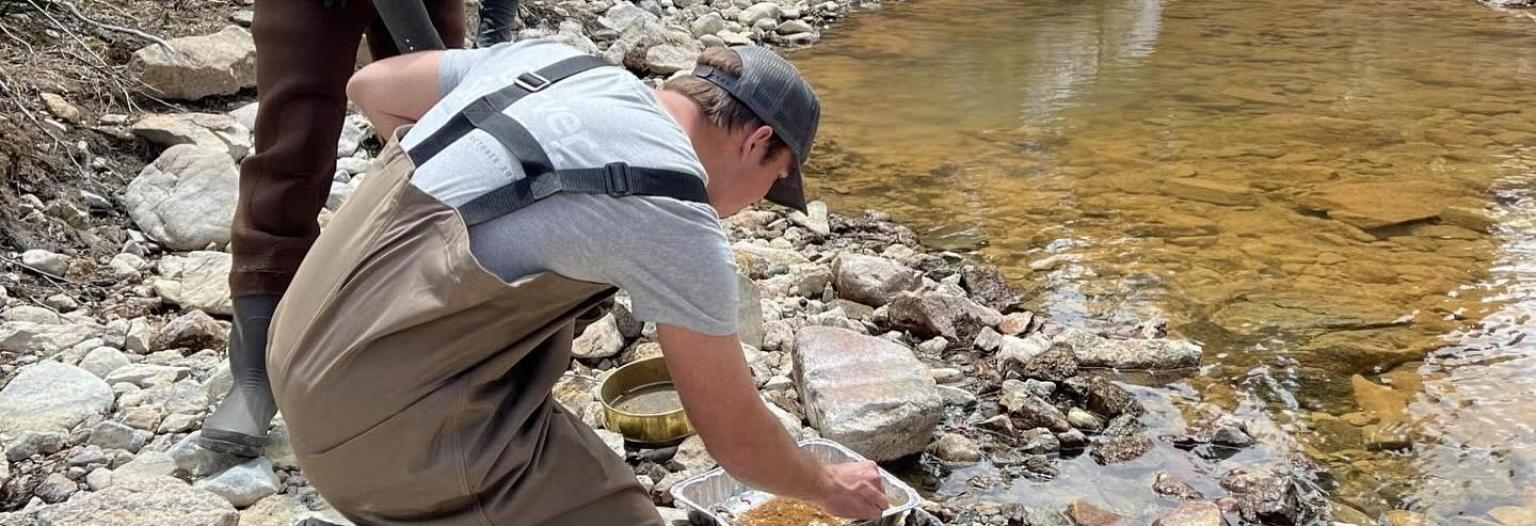 CU Boulder Master's students Athena Bolin and Adam Odorisio collect water samples from a creek near Aspen.