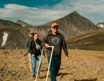 Researchers hike along mountain ridge