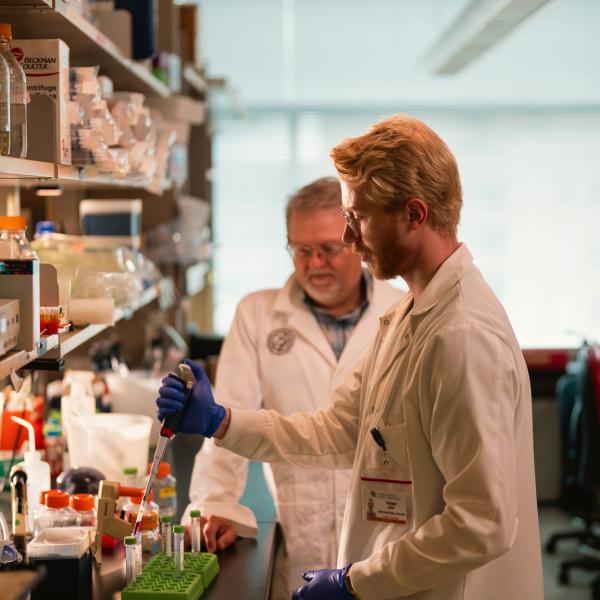 Two researchers studying proteins in a science lab