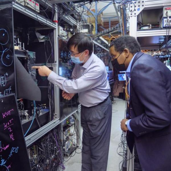 Two men review technical equipment in a laboratory